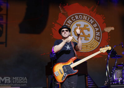 Matt Bissonette plays bass on stage in front of the band logo during the Brotherhood of Rock Tour.